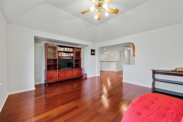 unfurnished living room featuring vaulted ceiling, dark hardwood / wood-style floors, and ceiling fan