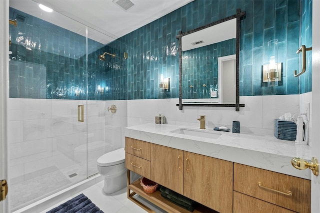 bathroom with vanity, tile walls, a shower with shower door, and toilet