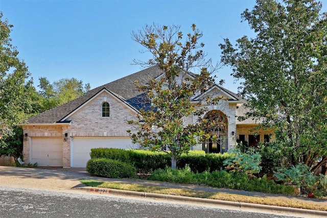 9228 Limoncillo Dr, Austin, TX 78750 - view of front of property with driveway, brick siding, an attached garage, and a shingled roof