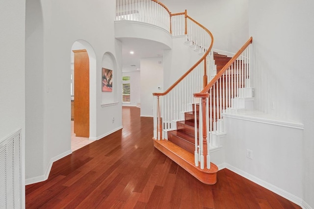 9228 Limoncillo Dr, Austin, TX 78750 - stairs with wood-type flooring, a towering ceiling, and arched walkways