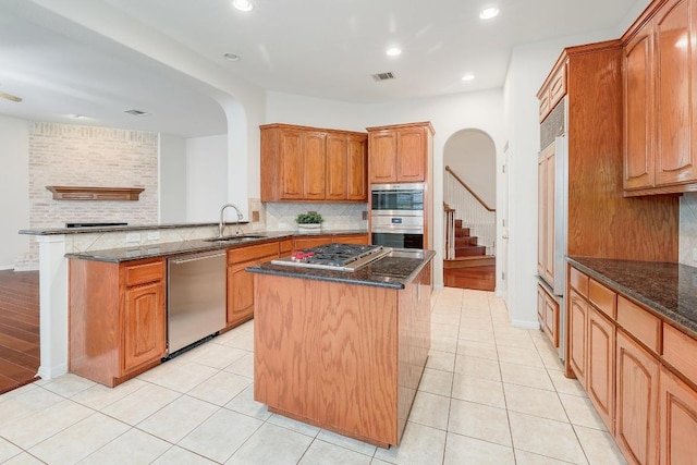9228 Limoncillo Dr, Austin, TX 78750 - kitchen featuring stainless steel appliances, arched walkways, a center island, backsplash, and recessed lighting