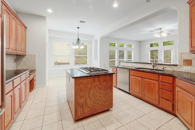 9228 Limoncillo Dr, Austin, TX 78750 - kitchen with stainless steel appliances, a kitchen island, backsplash, dark stone counters, and a chandelier