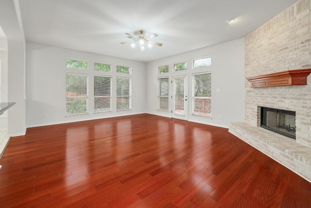 9228 Limoncillo Dr, Austin, TX 78750 - unfurnished living room featuring a ceiling fan, a brick fireplace, wood finished floors, and arched walkways