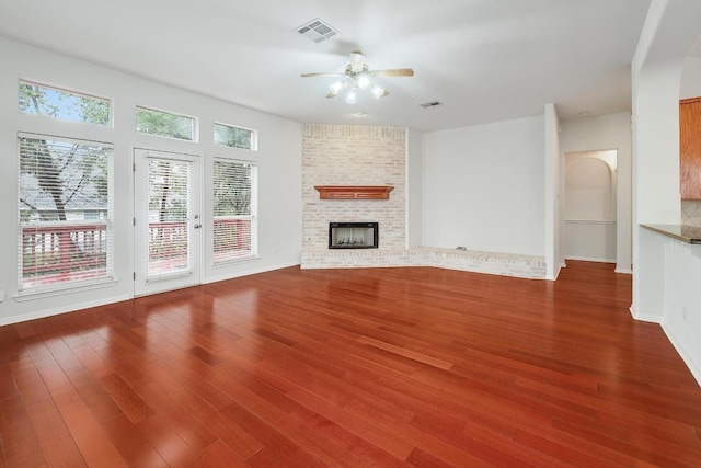 9228 Limoncillo Dr, Austin, TX 78750 - unfurnished living room with a ceiling fan, wood finished floors, arched walkways, and a brick fireplace