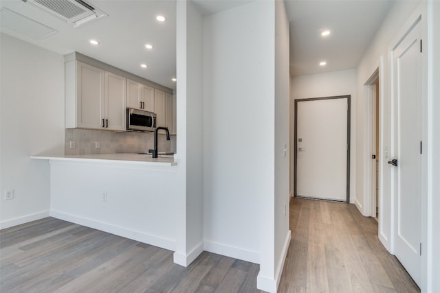 kitchen featuring sink, light hardwood / wood-style flooring, and tasteful backsplash