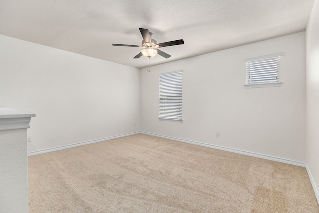 empty room with a textured ceiling, ceiling fan, and light carpet