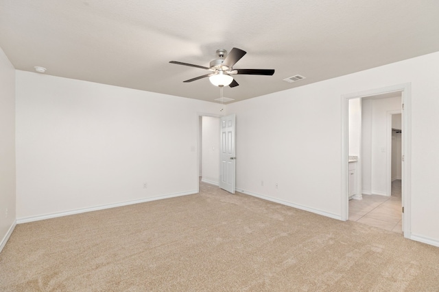 empty room with ceiling fan and light colored carpet