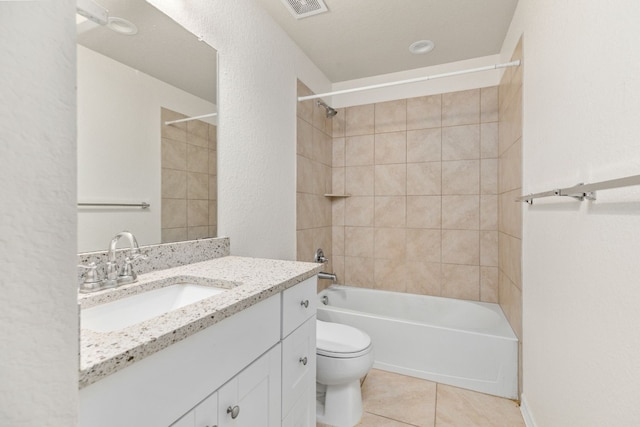 full bathroom with tiled shower / bath, vanity, toilet, and tile patterned floors