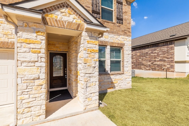 doorway to property featuring a yard and a garage