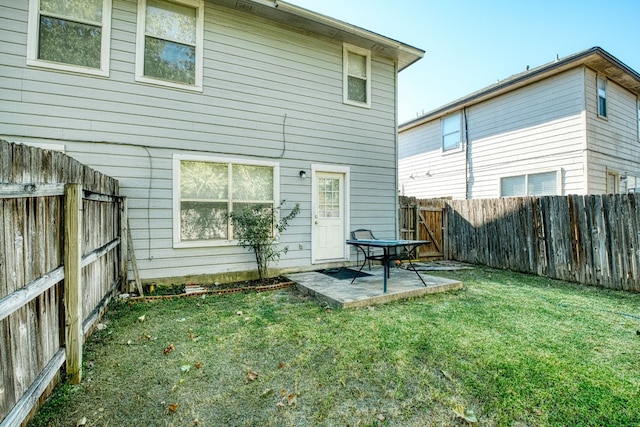 rear view of house with a yard and a patio