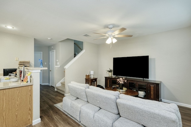 living room featuring ceiling fan and dark hardwood / wood-style flooring