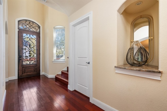 entrance foyer with dark hardwood / wood-style flooring and vaulted ceiling