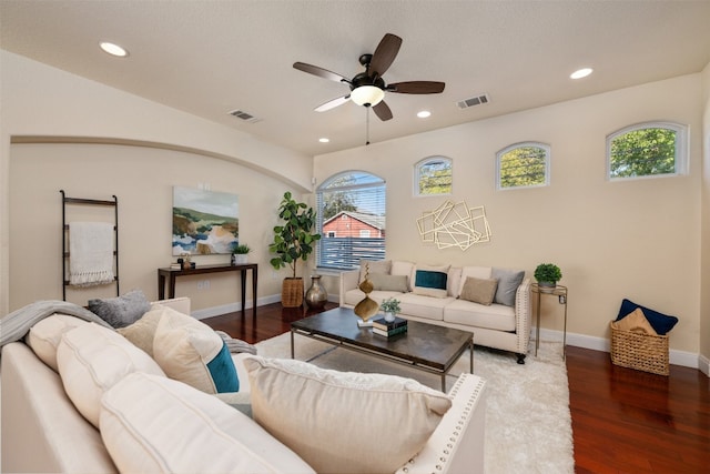 living room with dark hardwood / wood-style flooring, ceiling fan, and a healthy amount of sunlight