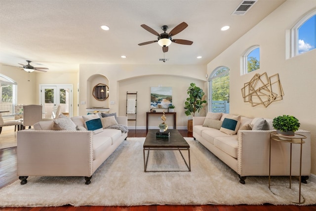 living room featuring hardwood / wood-style flooring, ceiling fan, a wealth of natural light, and french doors