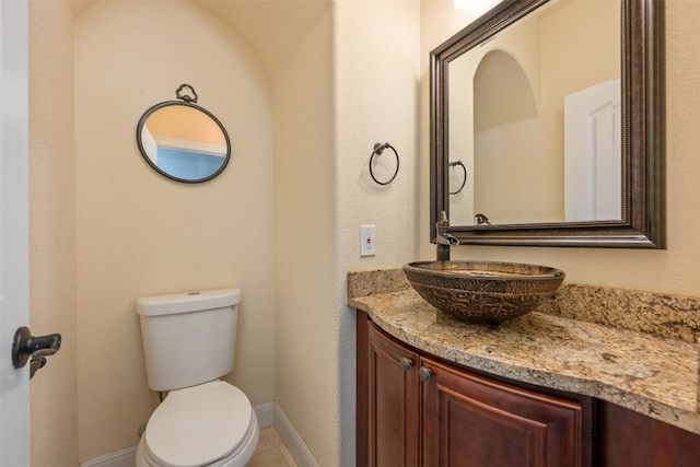 bathroom featuring tile patterned flooring, vanity, and toilet