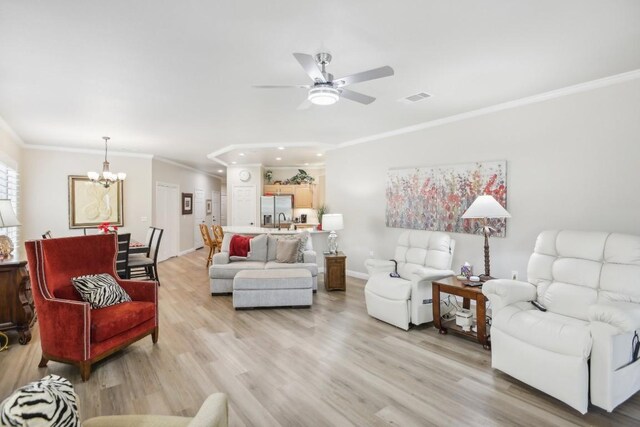 living room featuring crown molding, light hardwood / wood-style flooring, and ceiling fan with notable chandelier