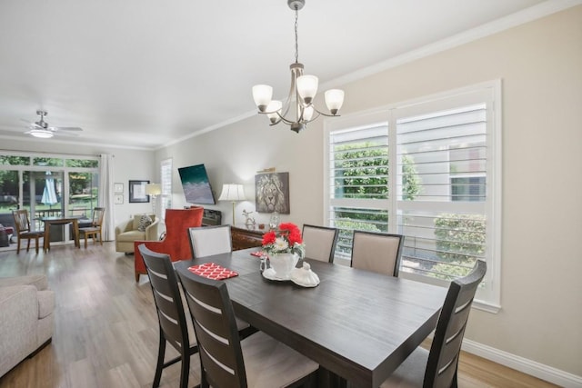 dining room featuring baseboards, ornamental molding, ceiling fan with notable chandelier, and light wood-style floors