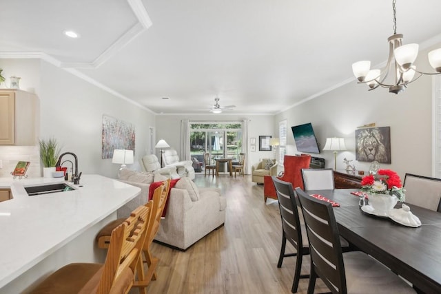 dining room featuring light wood-style floors, recessed lighting, ornamental molding, and ceiling fan with notable chandelier