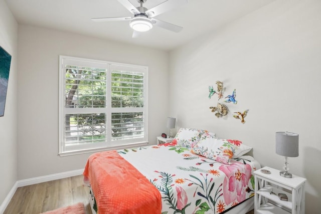 bedroom featuring wood finished floors, a ceiling fan, and baseboards