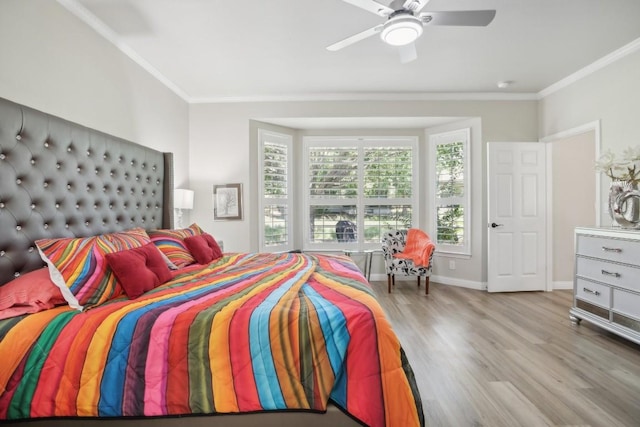 bedroom with ceiling fan, crown molding, baseboards, and wood finished floors