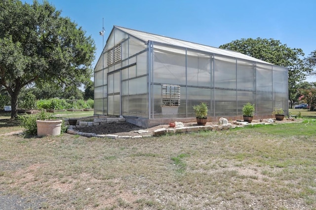 view of greenhouse with a lawn