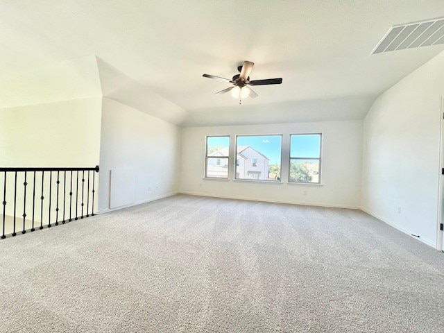 spare room featuring ceiling fan, light carpet, and vaulted ceiling