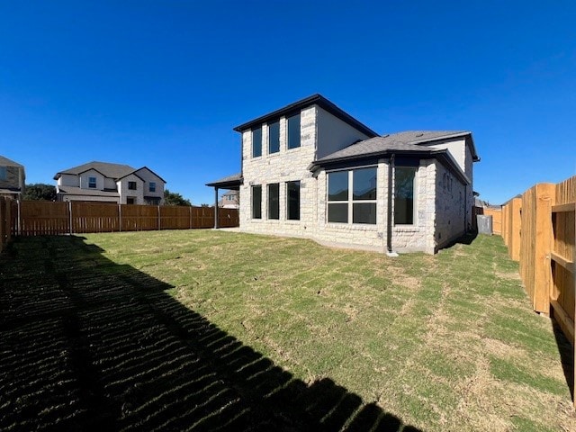 rear view of property featuring a lawn