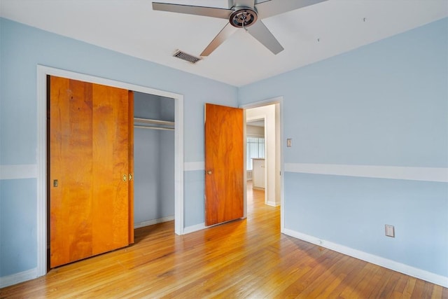 unfurnished bedroom featuring ceiling fan, a closet, and light hardwood / wood-style flooring