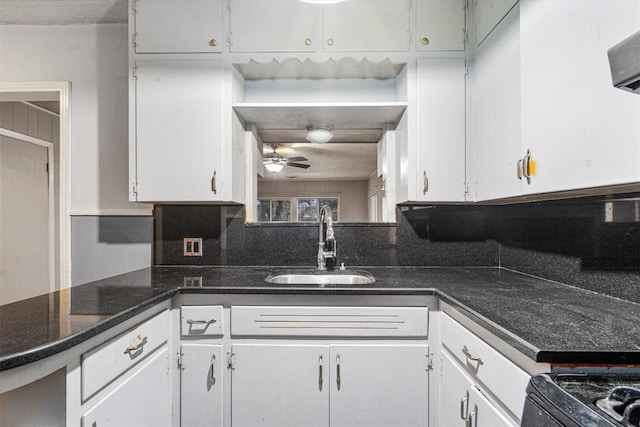 kitchen featuring ceiling fan, sink, and white cabinets