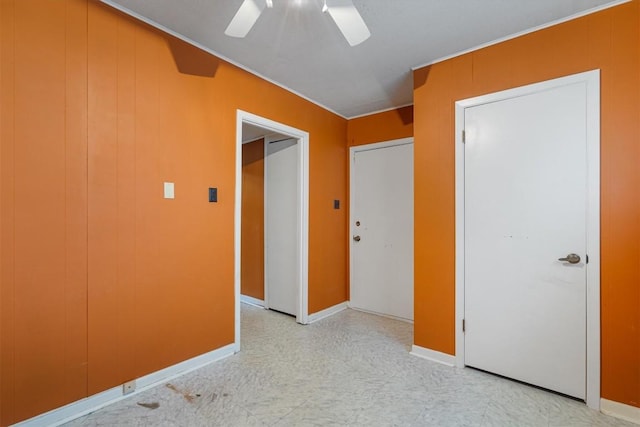 unfurnished bedroom with ceiling fan and wooden walls