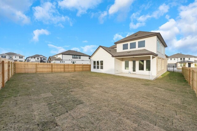 rear view of house with a lawn and a patio