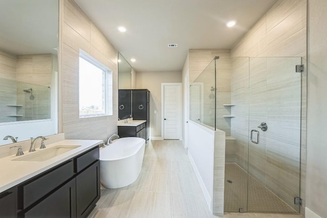 bathroom featuring shower with separate bathtub and vanity