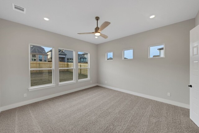 unfurnished room with ceiling fan and carpet