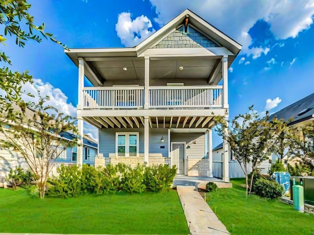 view of front of house with a balcony and a front yard