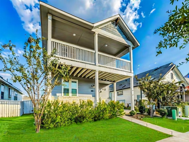 view of front facade featuring a balcony and a front lawn