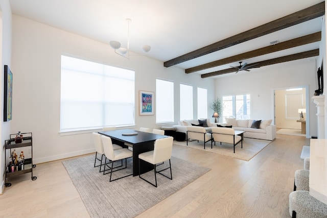 dining room featuring light wood-type flooring, ceiling fan with notable chandelier, and beam ceiling