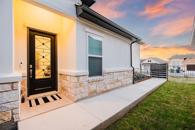 exterior entry at dusk with a yard