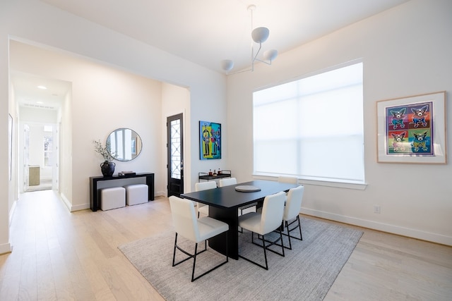 dining room featuring light hardwood / wood-style flooring and a notable chandelier