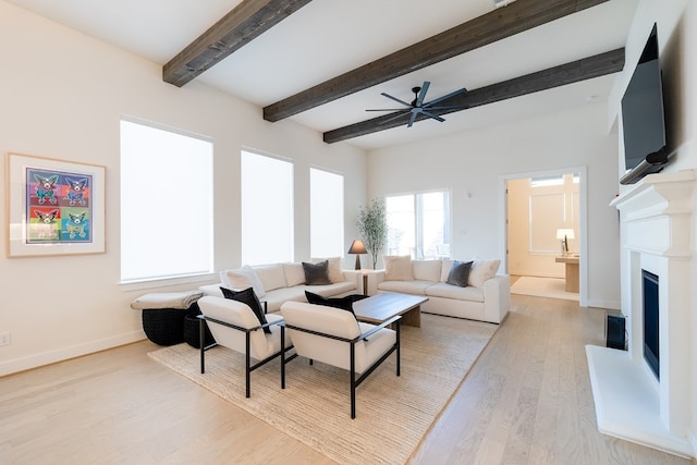 living room featuring light hardwood / wood-style floors, beam ceiling, and ceiling fan