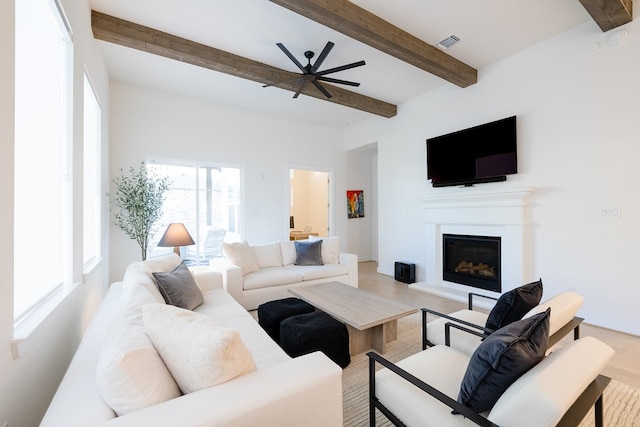 living room featuring ceiling fan, beamed ceiling, and hardwood / wood-style flooring