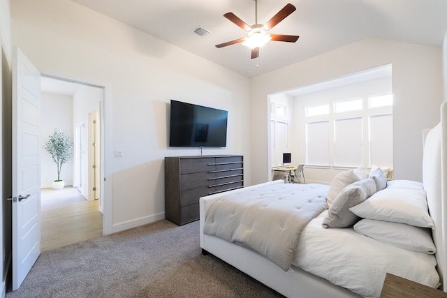 bedroom featuring ceiling fan, light colored carpet, and vaulted ceiling