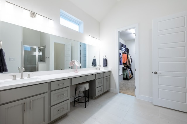 bathroom with tile patterned flooring, a shower with door, vaulted ceiling, and vanity