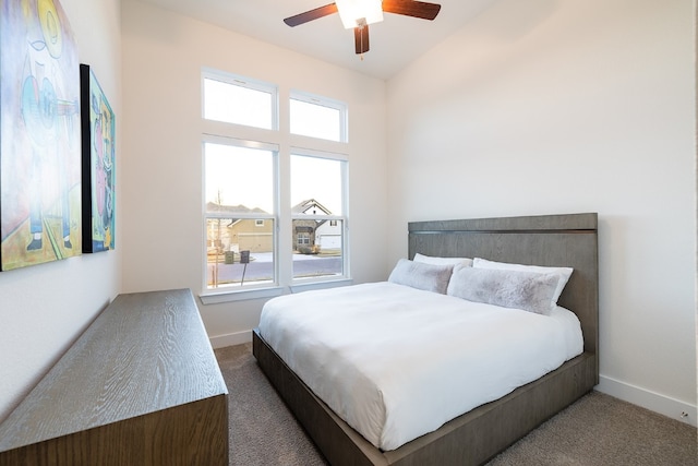 carpeted bedroom with multiple windows, vaulted ceiling, and ceiling fan