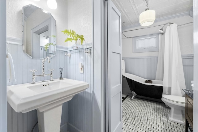 full bathroom featuring shower / bathtub combination with curtain, sink, crown molding, and toilet