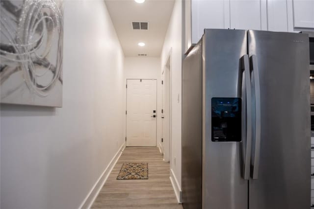 corridor with light hardwood / wood-style floors