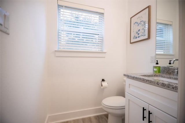 bathroom featuring vanity, hardwood / wood-style flooring, and toilet