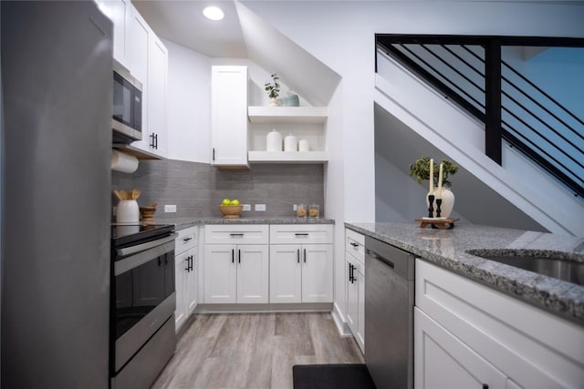 kitchen featuring stainless steel appliances, light stone countertops, light hardwood / wood-style flooring, and white cabinets