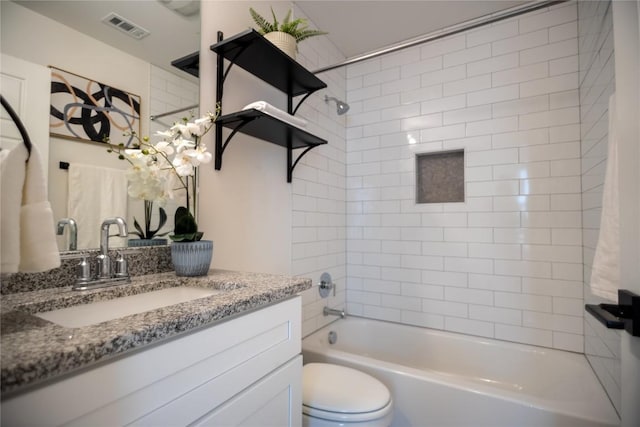 full bathroom featuring tiled shower / bath, vanity, and toilet