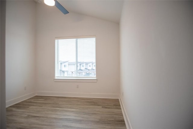 spare room with lofted ceiling, wood-type flooring, and ceiling fan