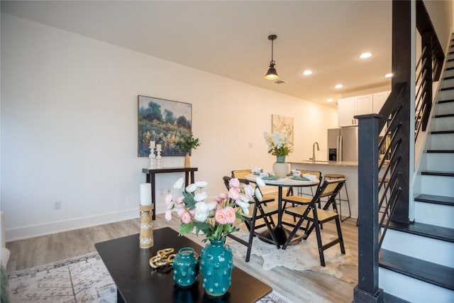 dining space featuring sink and light hardwood / wood-style flooring